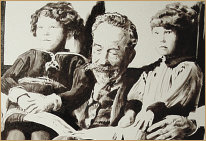 Artwork by Edward K Hudson of an old grandfather reading a book to his grandchildren